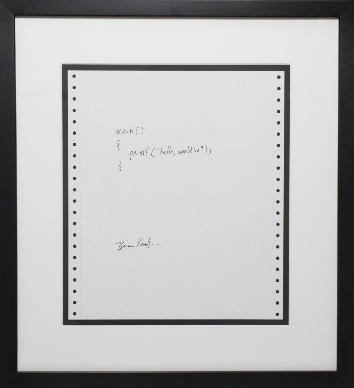 La frase «hello, world» escrita a mano en una hoja, firmada por Brian Kernighan
