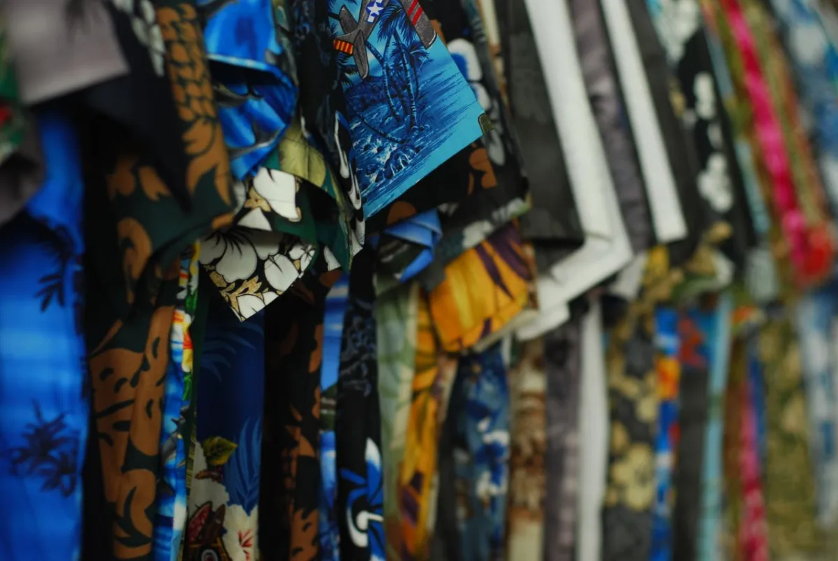 Camisas hawaianas de colores colgadas en un expositor de una tienda