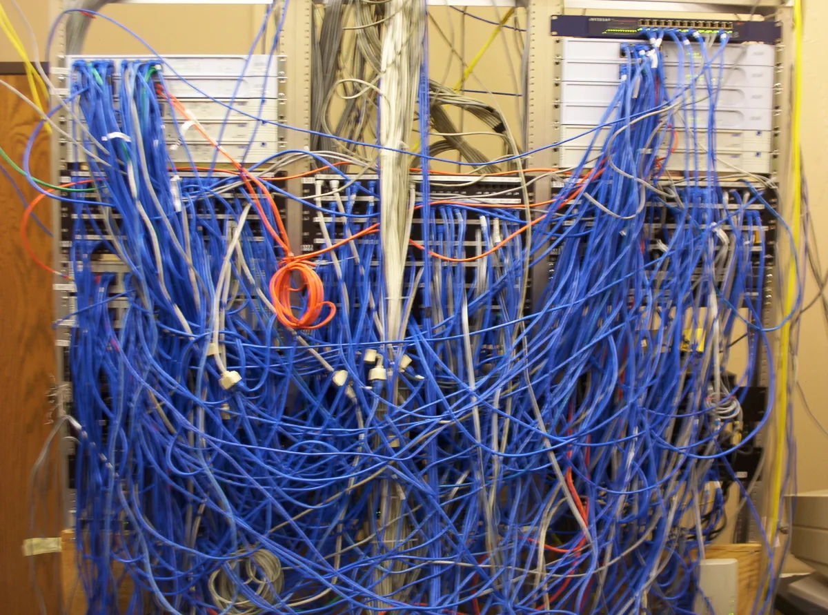Un armario de cableado de red con decenas de latiguillos de colores enredados