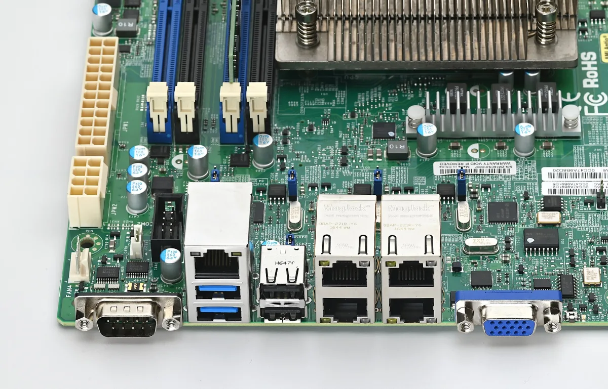 Detalle del panel trasero de una placa base de servidor: puerto serie, dos USB 3.0, un puerto de gestión remota, dos USB 2.0, cuatro puertos ethernet gigabit y un VGA