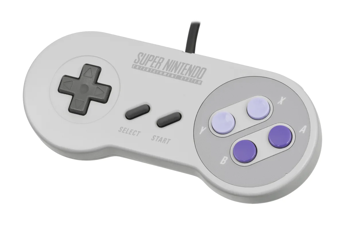 Un mando de Super Nintendo, gris, con la cruceta a la izquierda y los cuatro botones de colores a la derecha