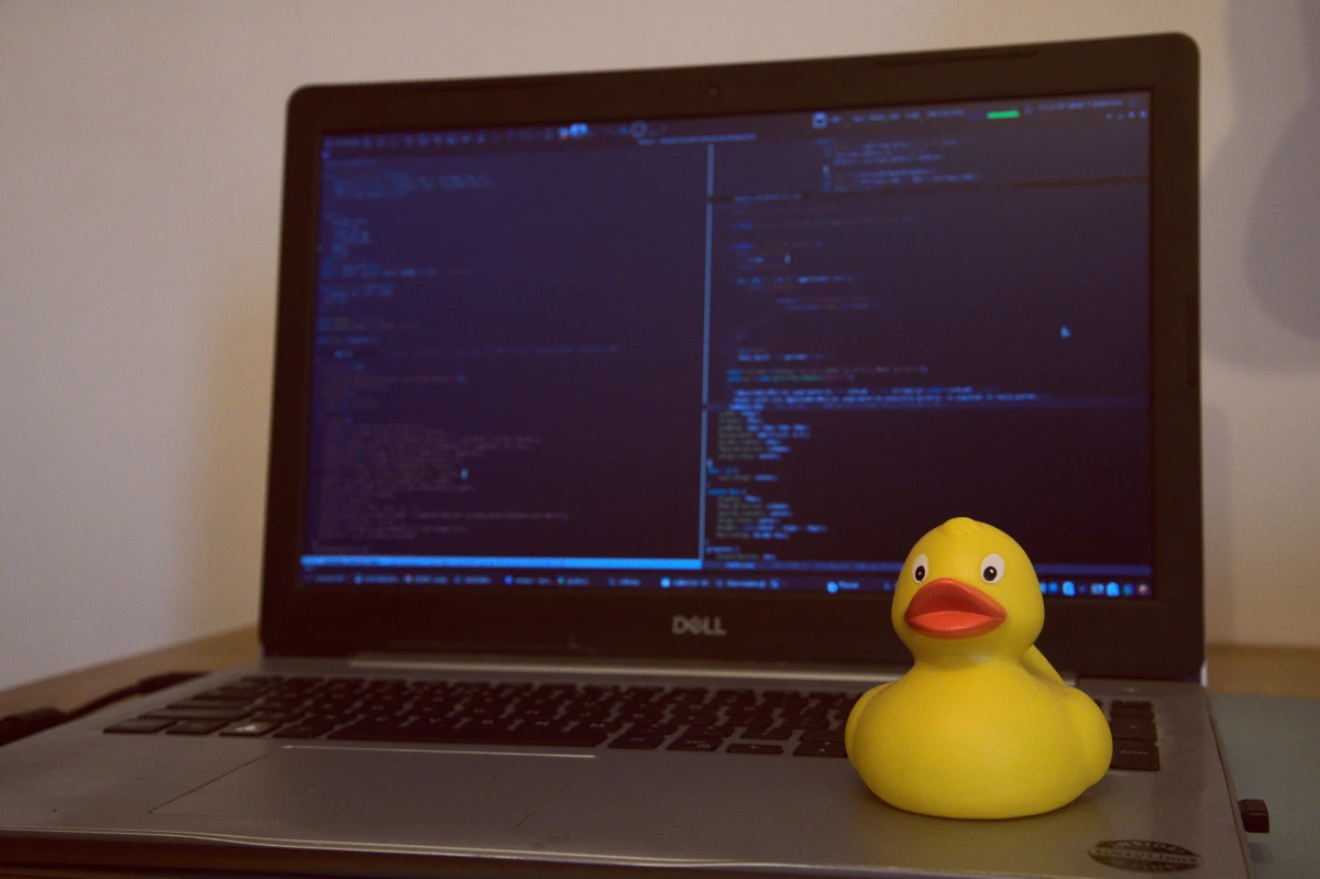 Un pato de goma amarillo delante de la pantalla de un ordenador con código