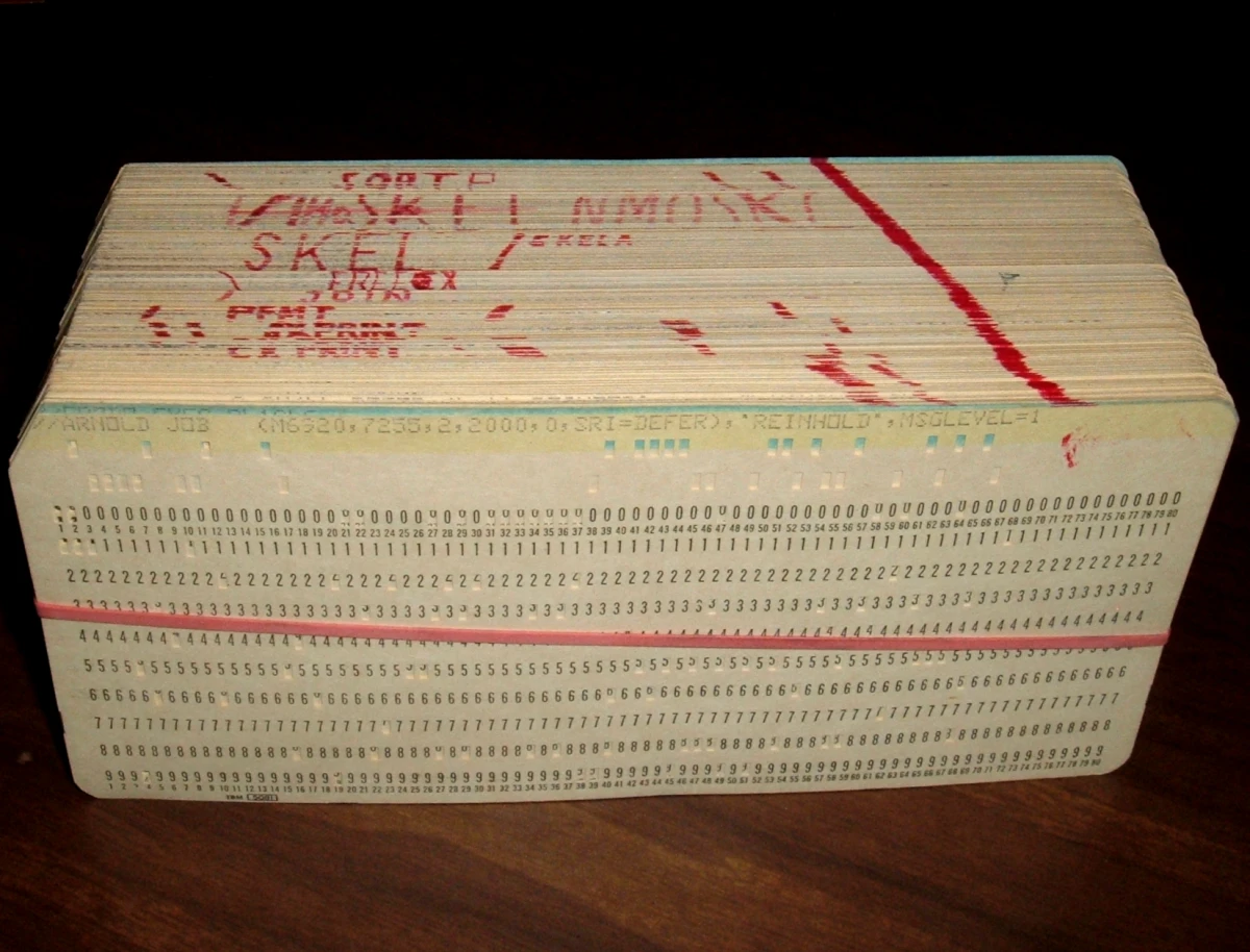 Un mazo de tarjetas perforadas de ordenador, apiladas y con una goma alrededor