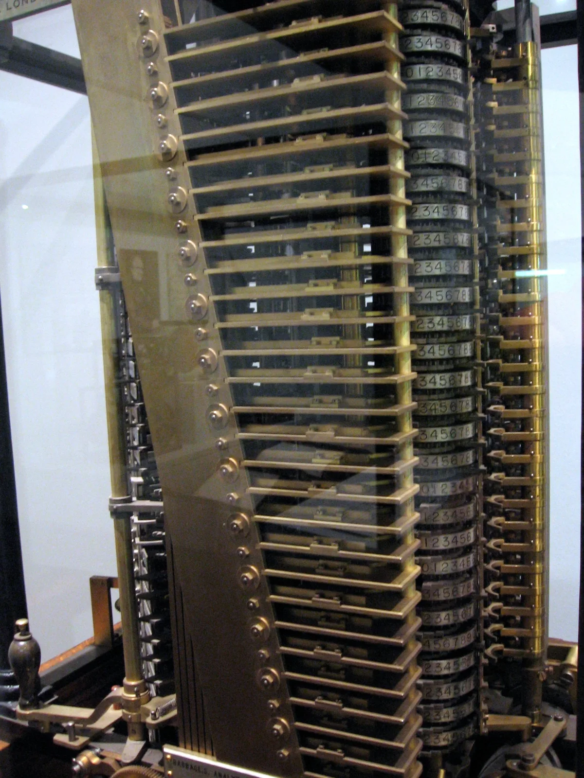 Molino de la máquina analítica de Babbage: columnas de engranajes y ruedas numeradas de latón tras una vitrina