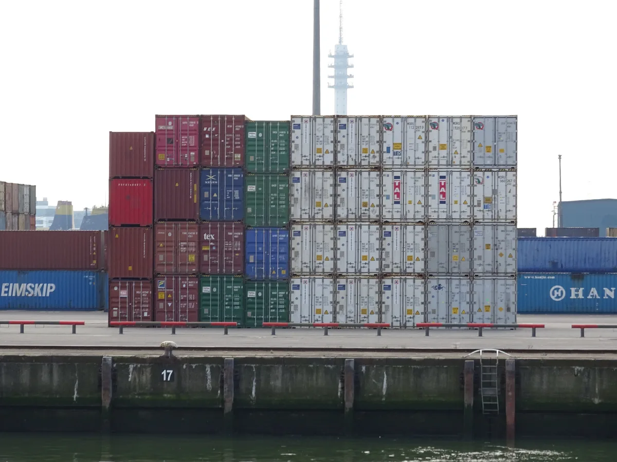 Pilas de contenedores marítimos de colores en una terminal portuaria