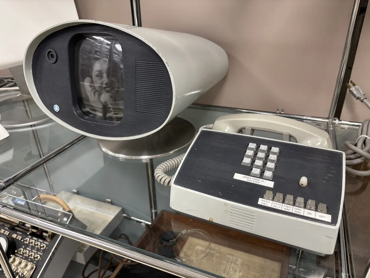 Un Picturephone de AT&T en una vitrina de museo: pantalla ovalada con cámara y, al lado, un panel con teclado y botones etiquetados VIDEO CALL, VIEW SELF, TWO WAY, ONE WAY, ON y OFF