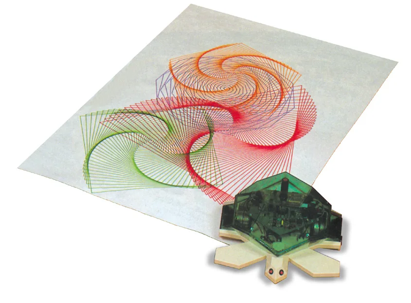 Una tortuga robot con la carcasa verde translúcida dejando ver la placa electrónica, junto a una hoja de papel con una figura de espirales dibujada en varios colores